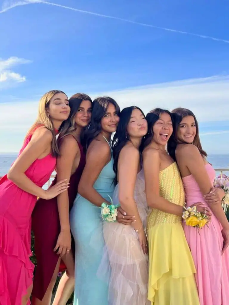 Group of friends posing in colorful dresses before prom.